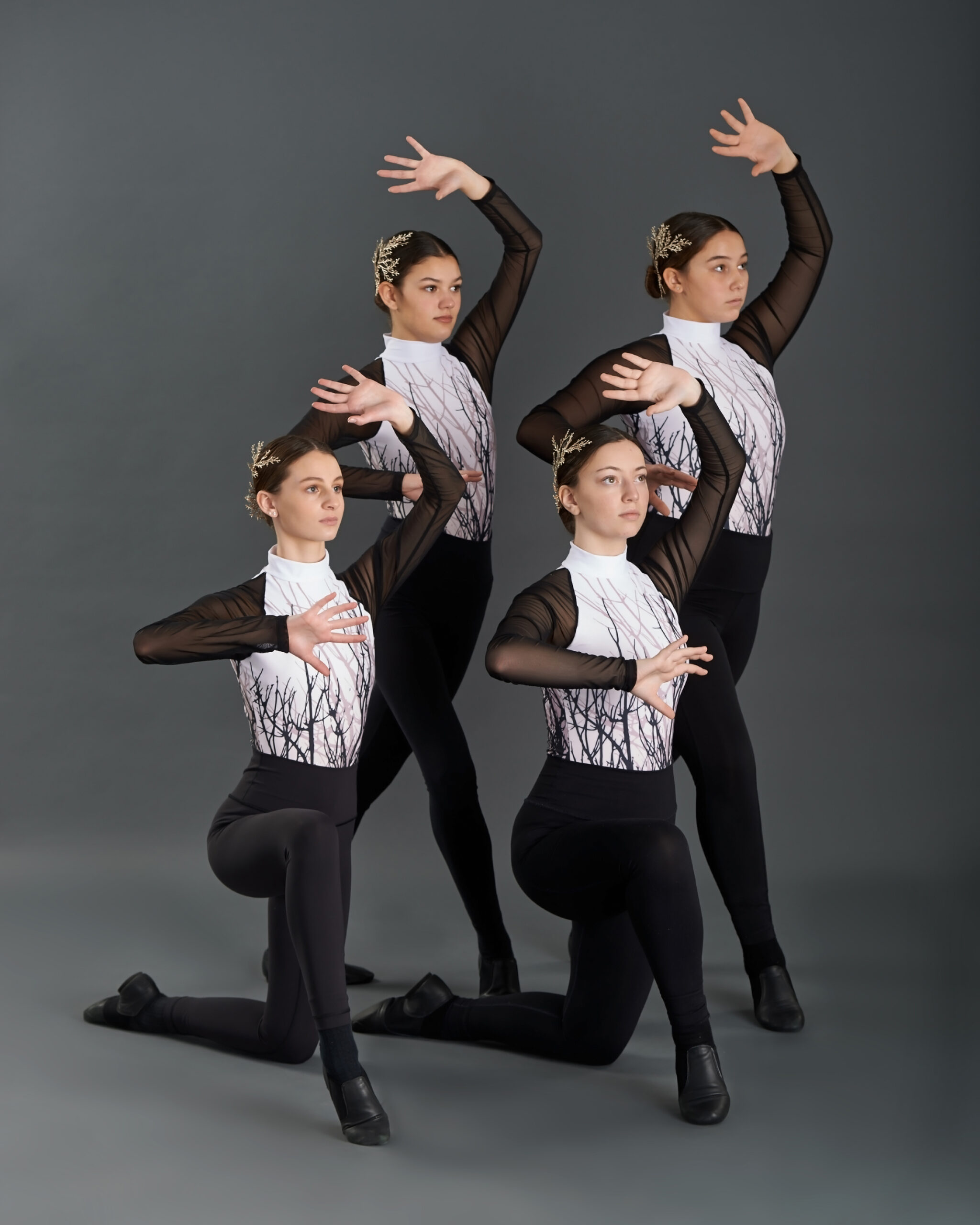 dance ensemble dancers posing in costumes with silver tops and black pants and shoes