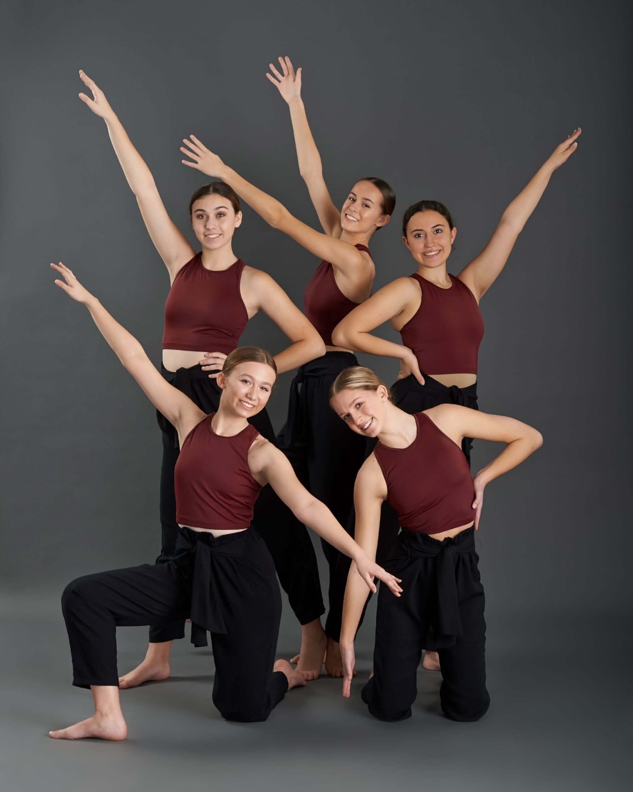 dancers posing in red shirts with black dance pants