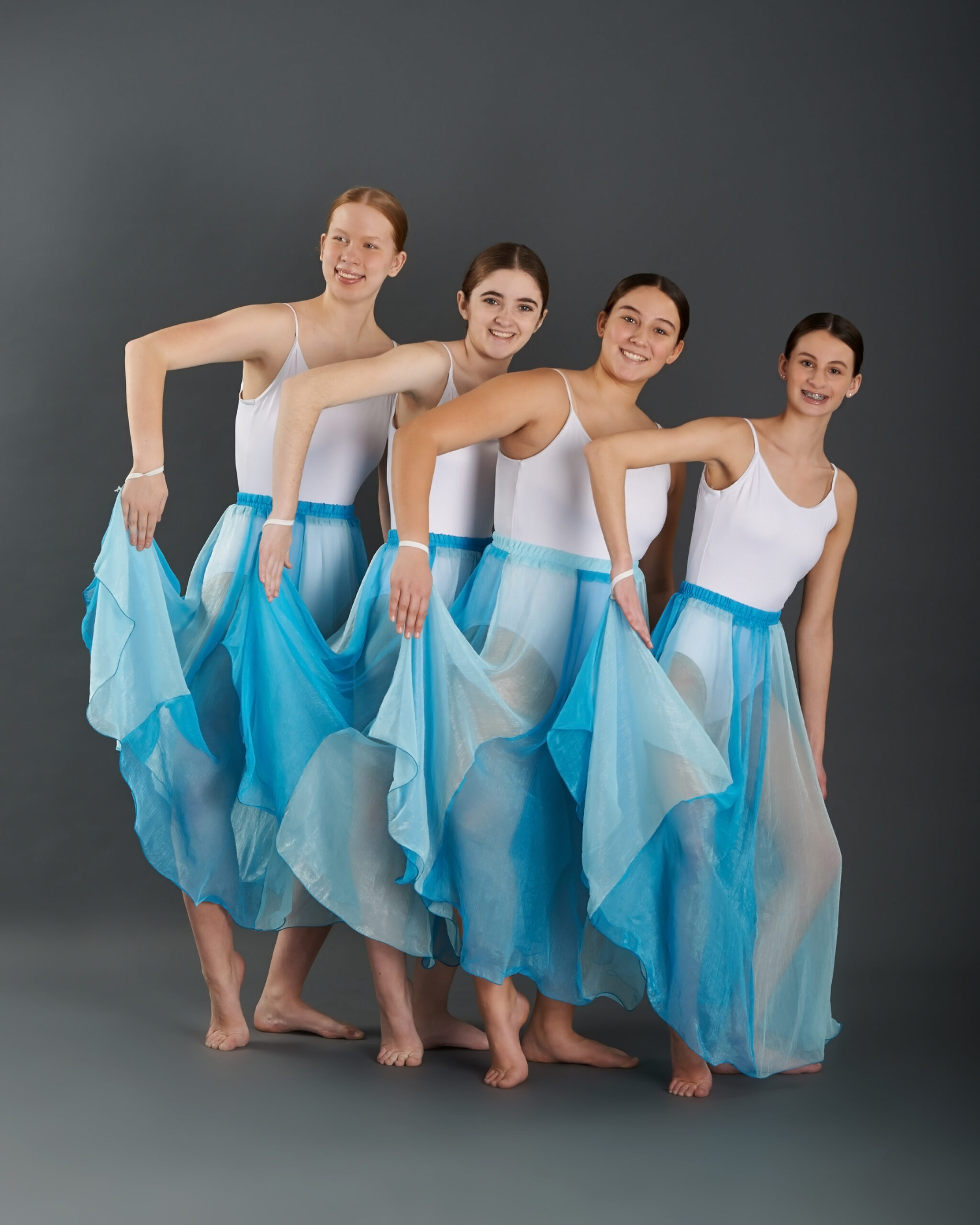 dance ensemble dancers posing in blue and white dresses
